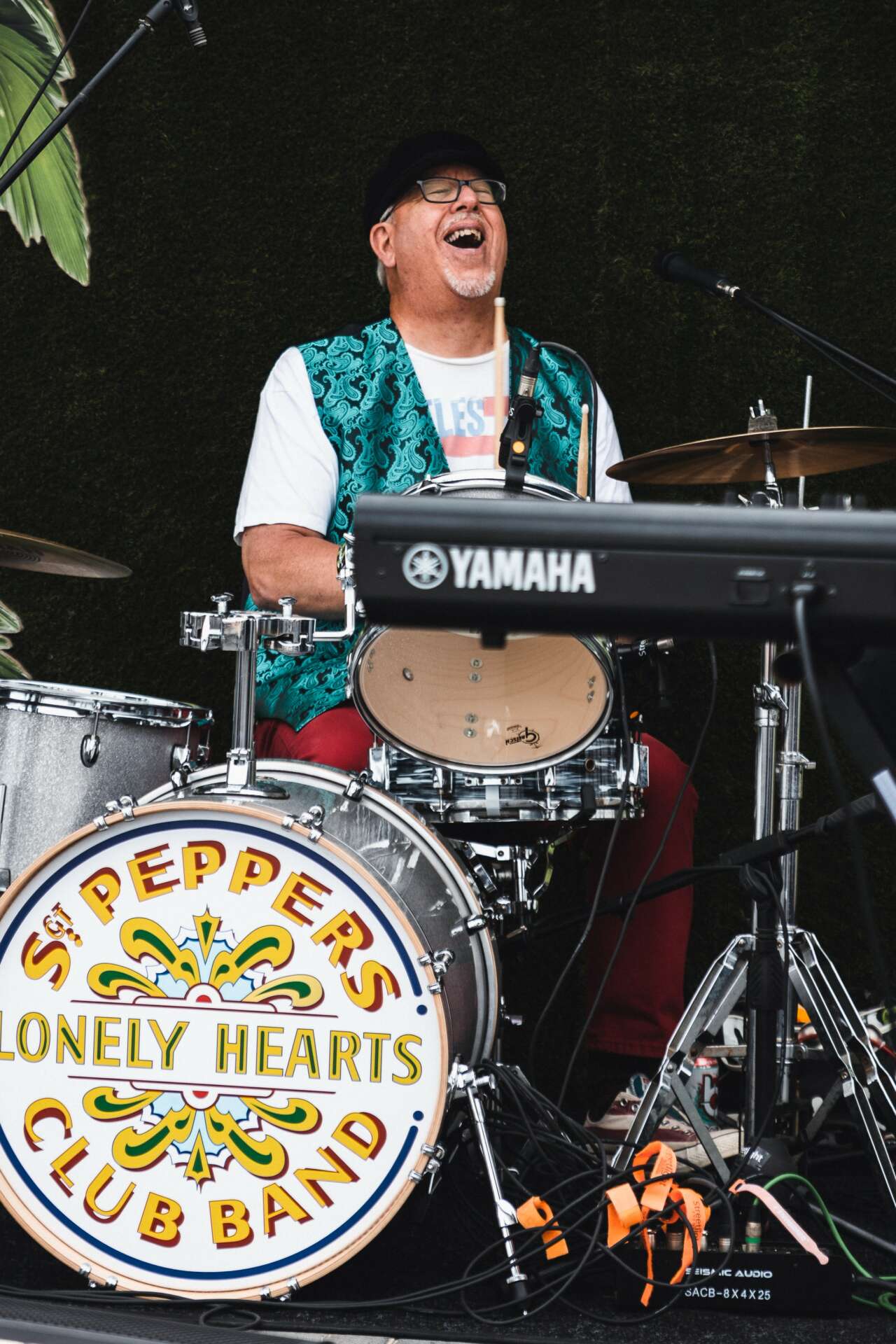 John Borack laughing while performing on drums with the St. Pepper's Lonely Hearts Club Band